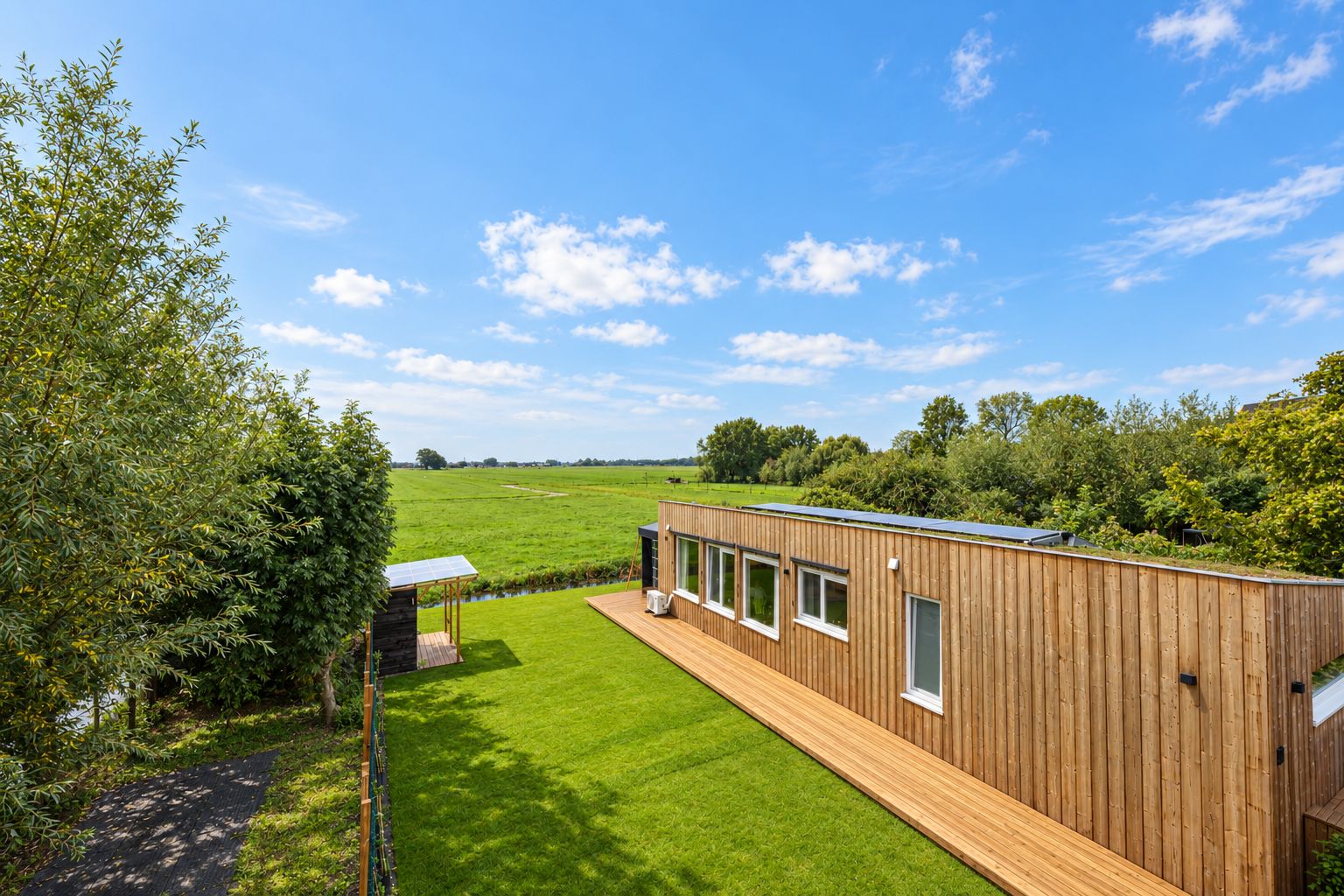 Plexatwoning met houten terras en gazon aan de Doetseweg, met uitzicht over de polder
