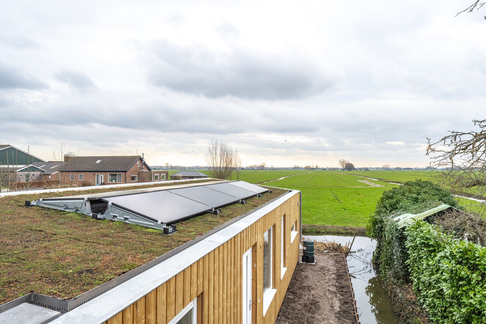 Groen dak met zonnepanelen en uitzicht over de polder bij de Doetseweg in Giessenburg