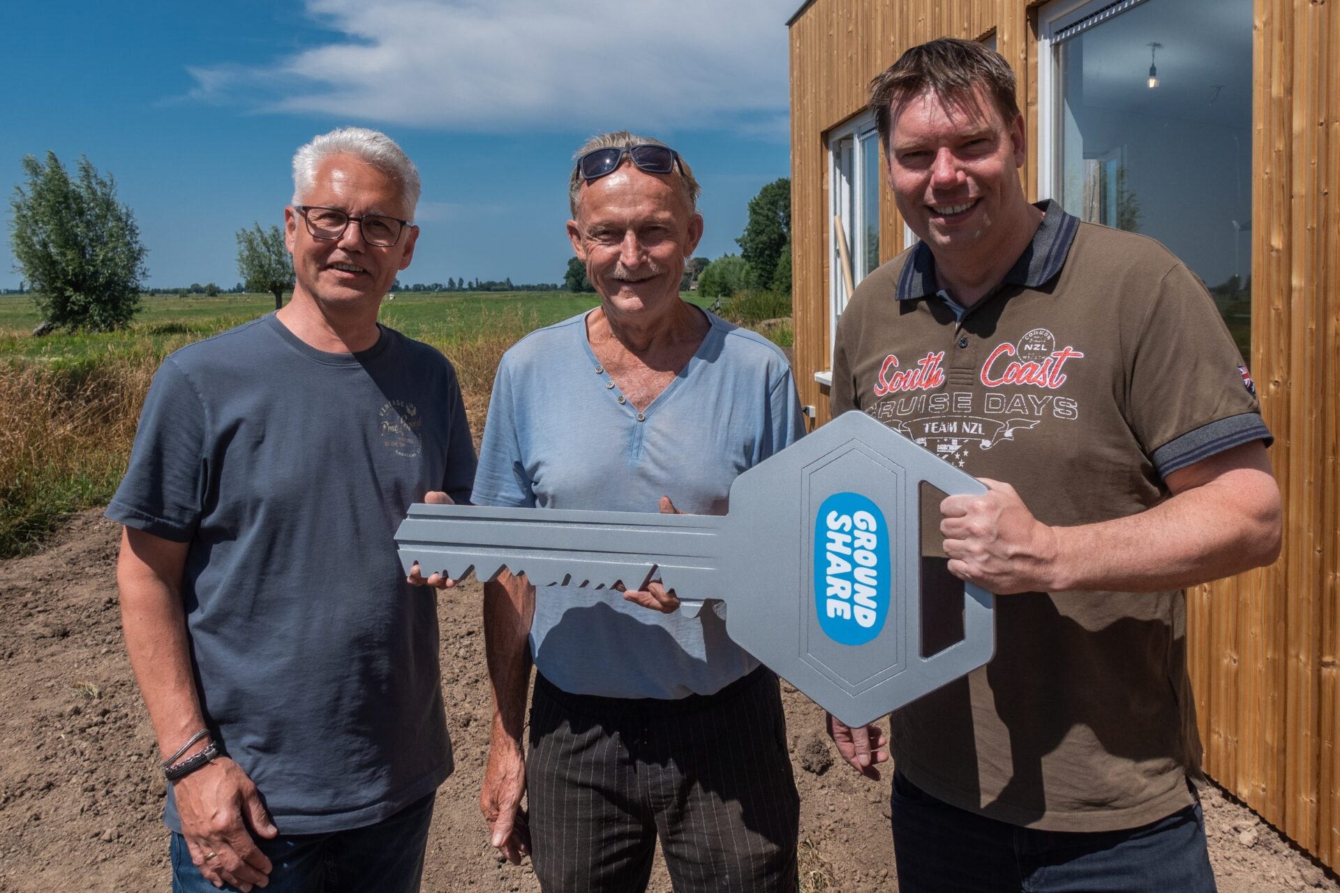 Edwin, grondeigenaar Jan en bewoner Willem met de Groundshare-sleutel bij de nieuwe woning