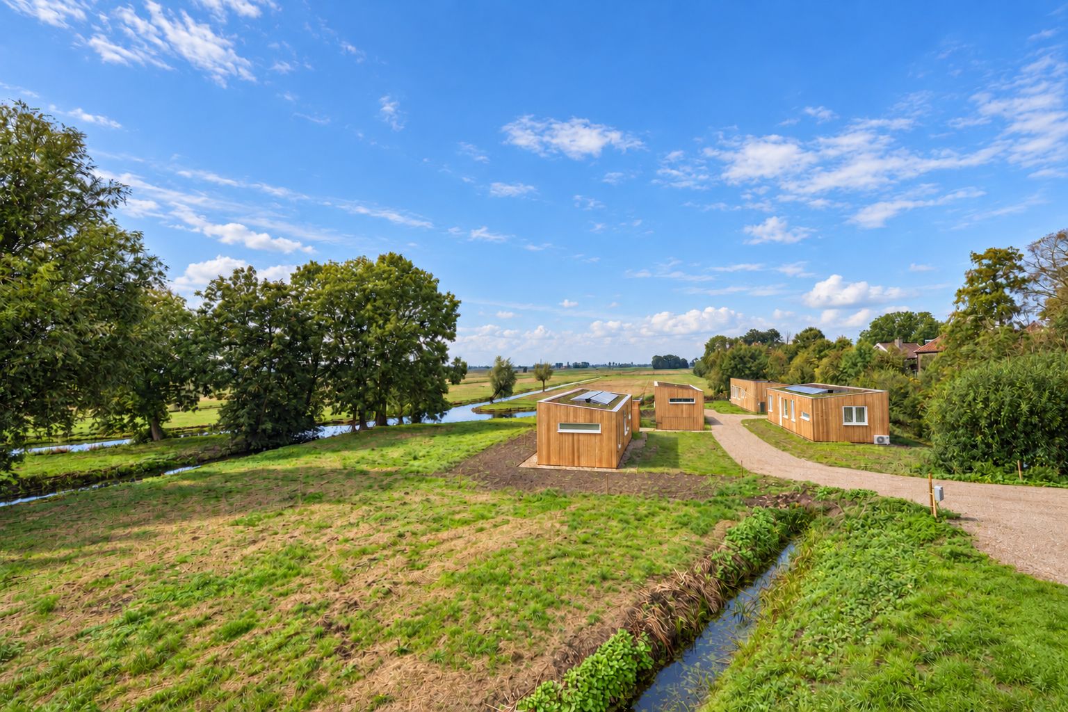 De Plexatwoningen aan de Peursumseweg in het weiland, gezien vanaf de sloot